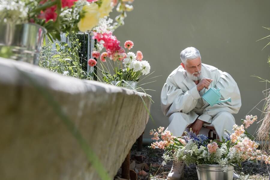 man watering container garden plants