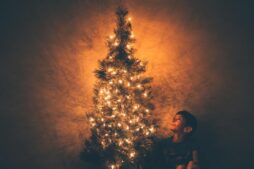 a child sitting by a christmas tree