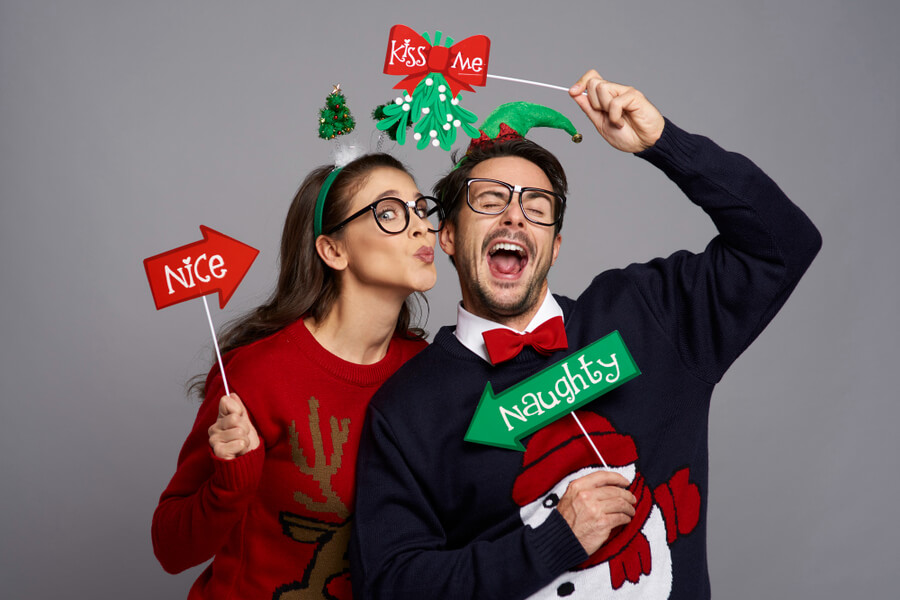 man and woman at a Christmas party with festive photo booth props