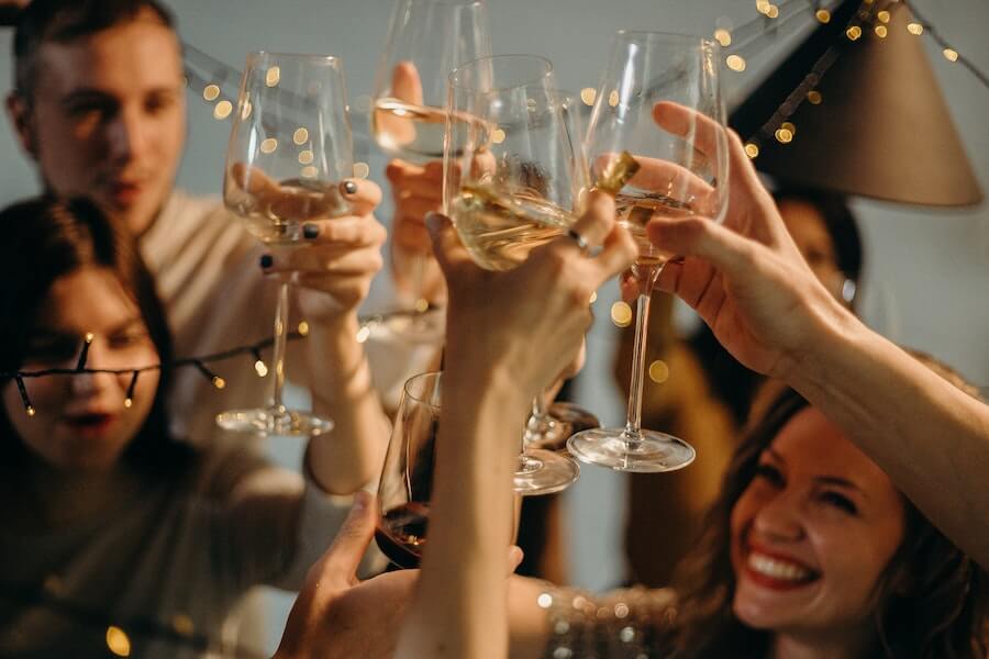 people raising glasses at a party of successful staff Christmas party ideas