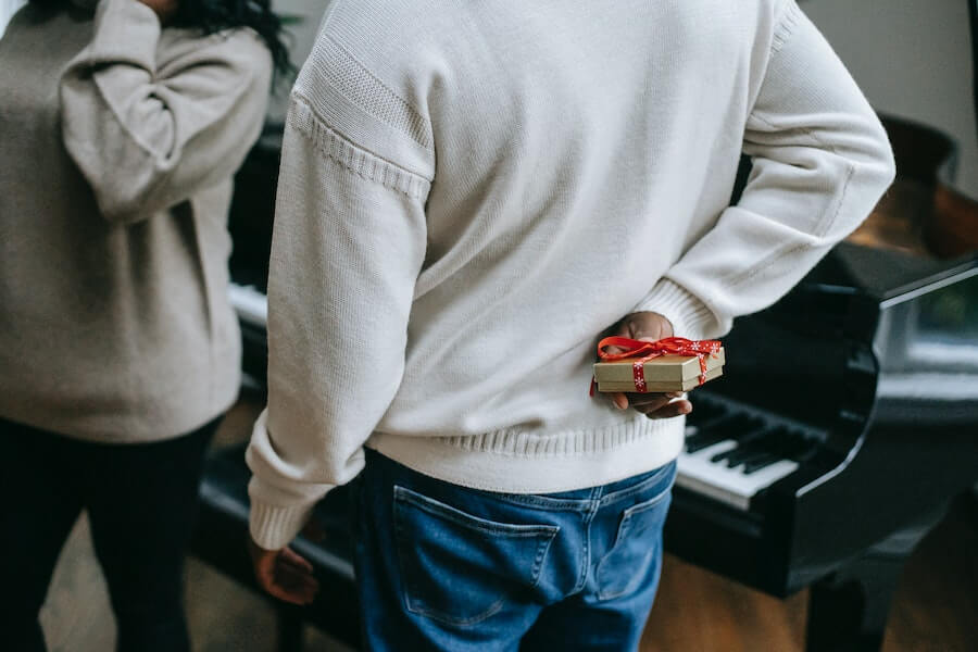 person hiding a Christmas gift for a fun family Christmas tradition