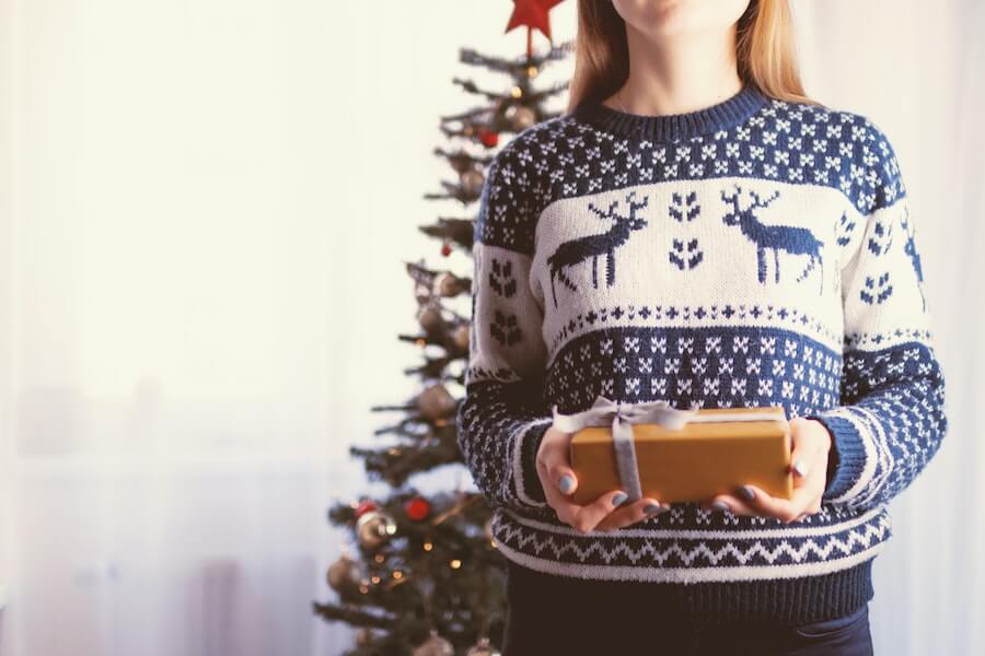 woman in a christmas jumper for a fun family christmas tradition