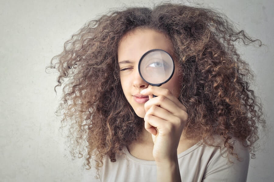 woman with a magnifying glass at a murder mystery party