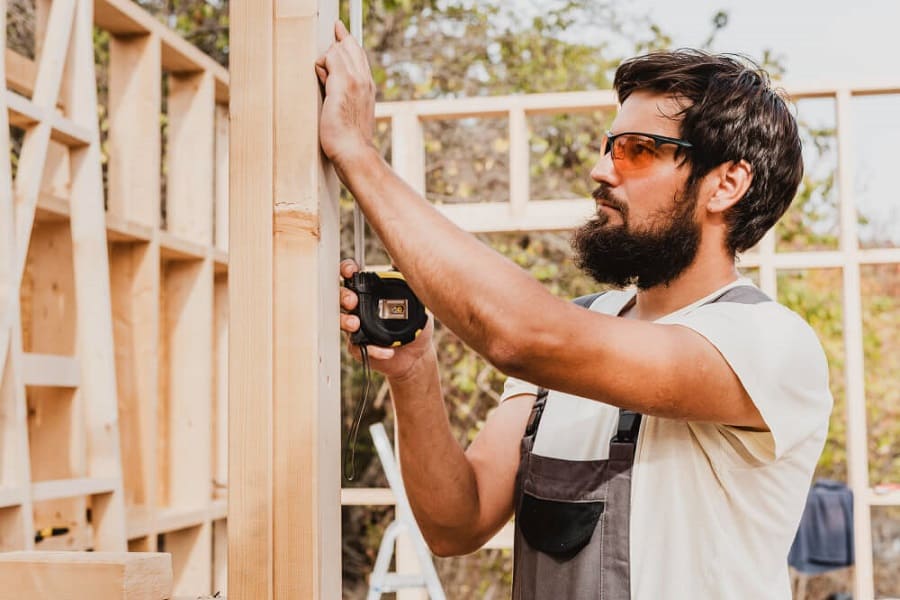 carpenter helping build wooden shed
